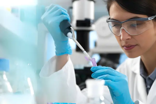 Pharmaceutical laboratory equipment and scientist hands close-up